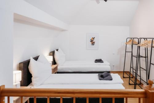 two beds in a room with white walls at FREE Parking, Nespresso, Netflix in Wels