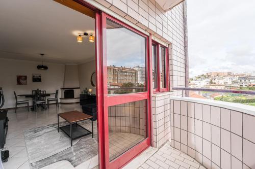 a room with a red door and a balcony at GuestReady - Restful stay in Vila Nova de Gaia in Vila Nova de Gaia