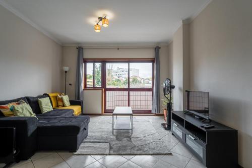 a living room with a couch and a tv at GuestReady - Restful stay in Vila Nova de Gaia in Vila Nova de Gaia