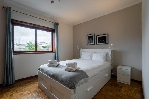 a bedroom with a large white bed with a window at GuestReady - Restful stay in Vila Nova de Gaia in Vila Nova de Gaia