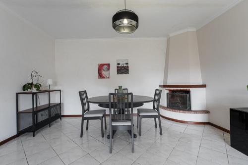 a dining room with a table and chairs and a fireplace at GuestReady - Restful stay in Vila Nova de Gaia in Vila Nova de Gaia