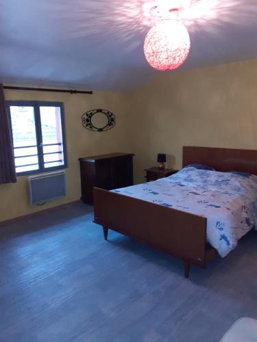 ein Schlafzimmer mit einem Bett und einem Kronleuchter in der Unterkunft A la maison in La Chaussée-sur-Marne