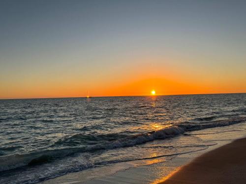 a sunset over the ocean with a beach and the sun at Blind Pass C106 - Upgraded Ground Floor Residence at Blind Pass in Sanibel