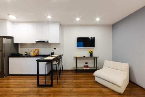 una cucina bianca con un divano bianco e un tavolo di Art 3C a Santa Cruz de la Sierra