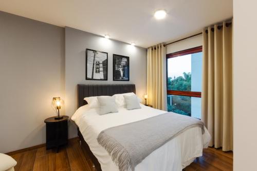 una camera da letto con un grande letto bianco con una finestra di Art 3C a Santa Cruz de la Sierra