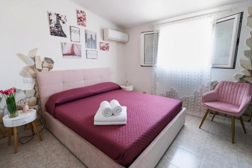a bedroom with a pink bed and a pink chair at L'albero di Beatrice in Quartu Sant'Elena
