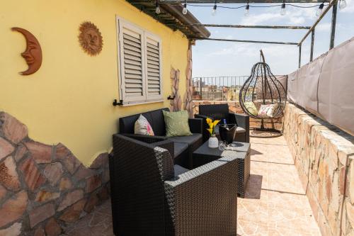 a patio with a couch and a table on a balcony at L'albero di Beatrice in Quartu Sant'Elena