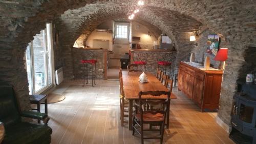 une salle à manger avec une table et des chaises dans un bâtiment dans l'établissement Mas cévenol en ardèche avec piscine privée, à La Celle-sous-Gouzon