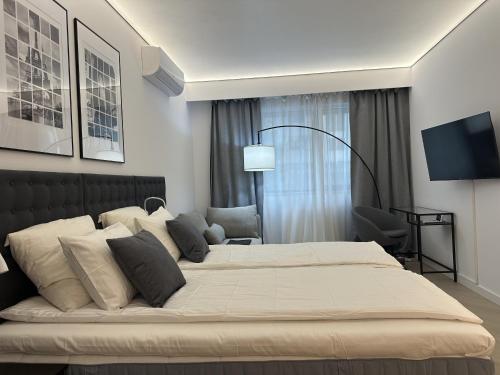 Un dormitorio con una cama grande y un televisor. en Urban Nest Pipera, en Pipera