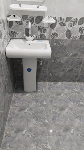 a bathroom with a white sink and a counter at Palace inn Guest House in Karachi