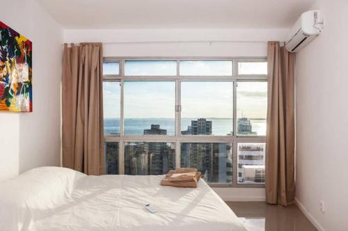 1 dormitorio con cama y ventana grande en Luxury Surround Sea View Apartment, en Salvador