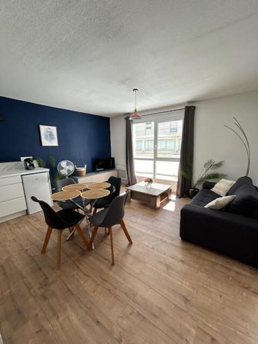 un salon avec un canapé, une table et des chaises dans l'établissement Appartement T2 proche gare et centre ville, à Sète