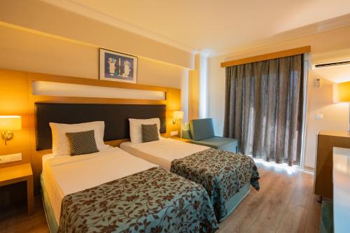 a hotel room with two beds and a window at Marbel Hotel by PalmWings in Kusadası
