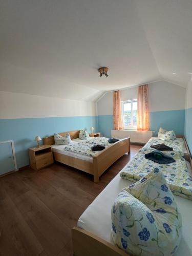two beds in a room with blue walls at Ferienwohnungen Hennig in Ahlbeck