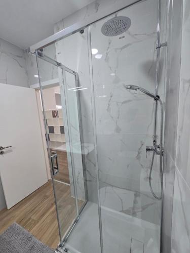 a shower with a glass door in a bathroom at Casa da Praça in Condeixa a Nova