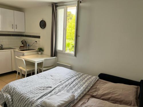 une chambre avec un lit et une table et une cuisine dans l'établissement studio bord de mer, à Saint-Raphaël