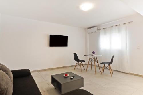a living room with a couch and chairs and a table at The Central Stay in Karpathos Town