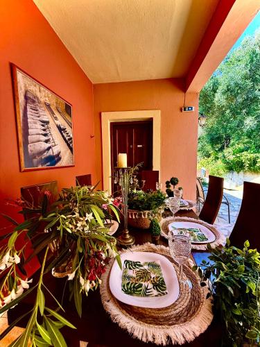 a dining room with a table with plates and plants at TRAVELLERS BEAUTIFUL ELEN Agios Gordios Sea in Agios Gordios