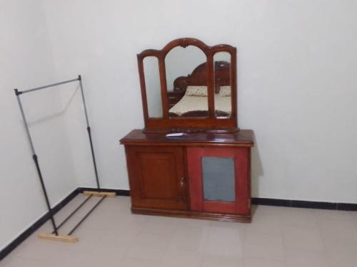 a mirror sitting on top of a dresser in a room at Un T1 CHARMANT in Sangalkam