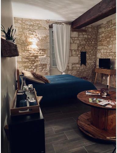 une chambre avec un lit et une table dedans dans l'établissement La Gouronerie, à Parçay-sur-Vienne