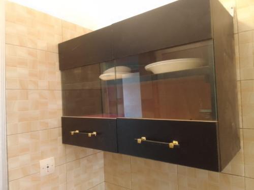 a cabinet with a plate in it in a bathroom at Un T1 CHARMANT in Sangalkam