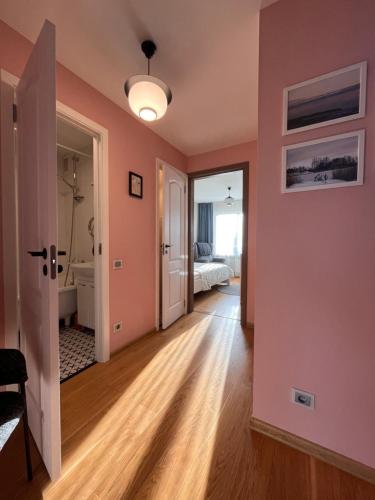 a room with pink walls and a bedroom with a bed at SUNSET Apartment Near Sea - Family Friendly space with Bath and Good Coffee in Ventspils