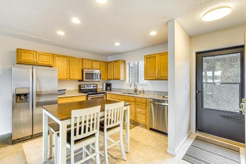 a kitchen with a wooden table and a refrigerator at Lakefront Osage Beach Condo Main Channel View! in Osage Beach