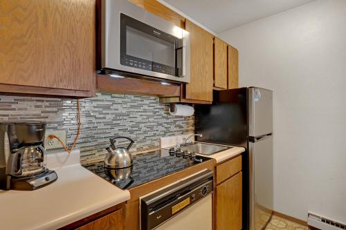 una cocina con estufa y microondas en Double Eagle A12 by Ski Country Resorts, en Breckenridge