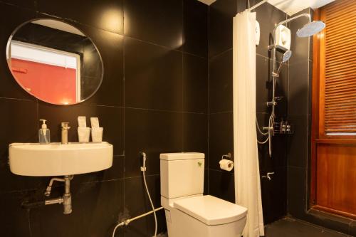 a bathroom with a toilet and a sink and a mirror at House Of Papa Bangkok Siam in Bangkok