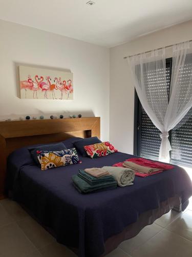 - une chambre avec un lit bleu avec des oreillers et une fenêtre dans l'établissement Villa Porto Vecchio, à Porto-Vecchio