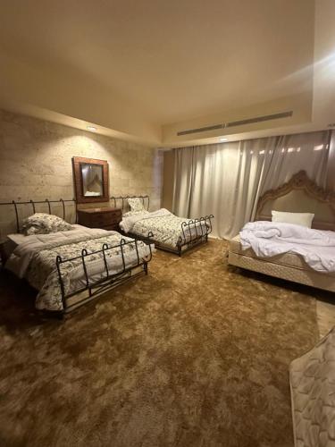 a bedroom with three beds and a table in it at villa sea view in Jeddah