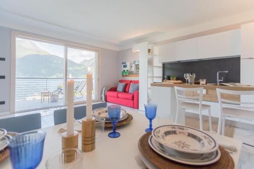 a kitchen and living room with a dining room and a table at Misultin House & Swimming pool, Luxury in Lake Como by Rent All Como in Pianello Del Lario