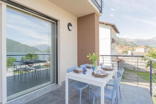 a white table and chairs on a balcony with a view at Misultin House & Swimming pool, Luxury in Lake Como by Rent All Como in Pianello Del Lario