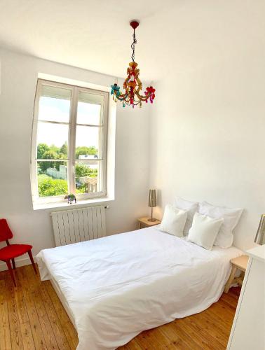 - une chambre avec un lit blanc, une fenêtre et un lustre dans l'établissement Spacious & bright property on D-Day Beaches, à Ver-sur-Mer