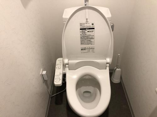 a bathroom with a toilet with a remote control at New Built Apartment Hokusai-kan Osaka Nishinari in Osaka