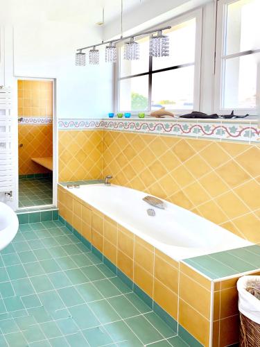 La salle de bains est pourvue d'une baignoire et de carrelage. dans l'établissement Spacious & bright property on D-Day Beaches, à Ver-sur-Mer