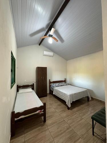 a bedroom with two beds and a ceiling fan at Chalés Relíquias da Canastra Il in São Roque de Minas