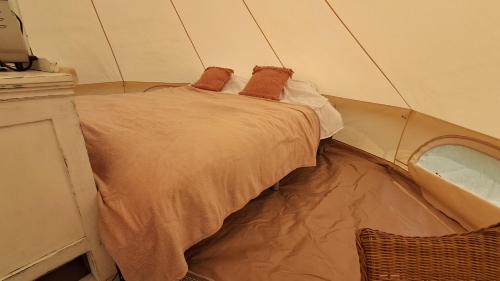 a small bed in a room with a mirror at Bell-tent Luna met uitzicht in Hensbroek