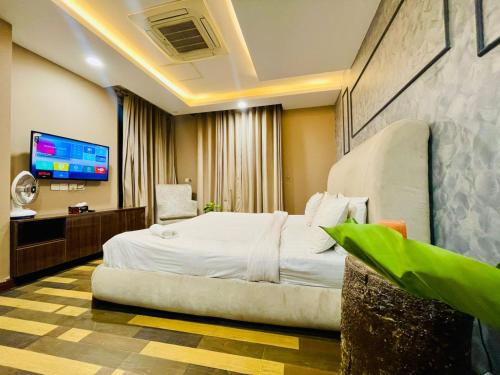 a hotel room with a bed and a flat screen tv at Luxurious One-Bedroom Gold Crest Apartment with Stunning Balcony Retreat DHA Lahore in Dargai