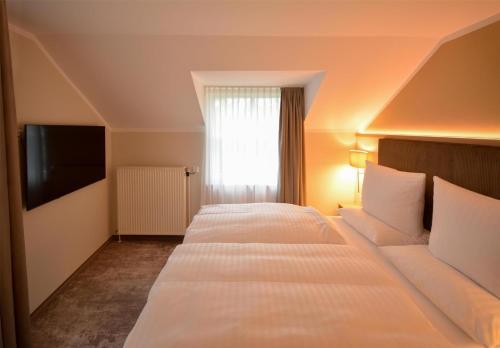 a hotel room with two beds and a window at Dorint Strandresort & Spa Ostseebad Wustrow in Wustrow