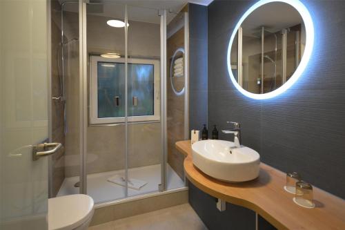 a bathroom with a sink and a shower at Dorint Strandresort & Spa Ostseebad Wustrow in Wustrow