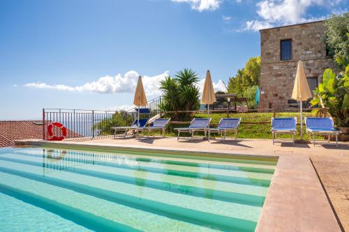 een zwembad met stoelen en parasols bij CefalHome - TORRE in Cefalù
