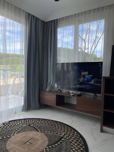 a living room with a large screen tv and windows at Jasmine Resort & Aqua park in Sharm El Sheikh