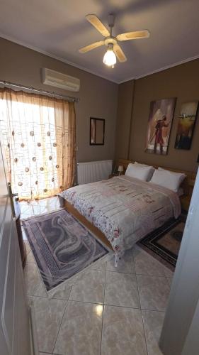 a bedroom with a bed and a ceiling fan at Dimitris gerakas apartment in Mesochórion