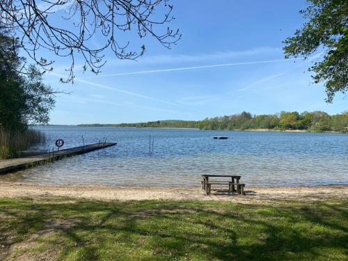 a picnic table sitting on the shore of a lake at PALEO House in Kristianstad