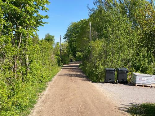 a dirt road with two trash cans on the side at PALEO House in Kristianstad