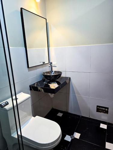 a bathroom with a sink and a toilet and a mirror at Andenes del Inca Hotel in Ollantaytambo