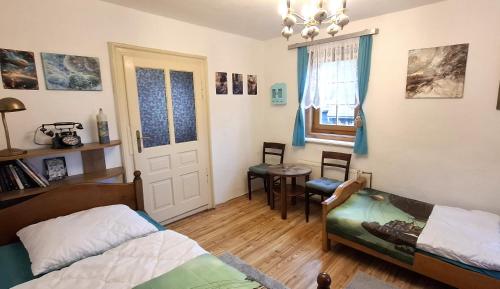 a bedroom with a bed and a table and a window at Chalupa Medium in Krásná Lípa