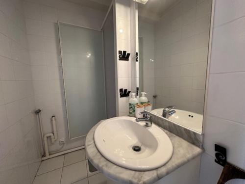 une salle de bain blanche avec un lavabo et une douche dans l'établissement Studio mezzanine climatisé 4 pers à Le Barcarès - FR-1-799-56, au Barcarès