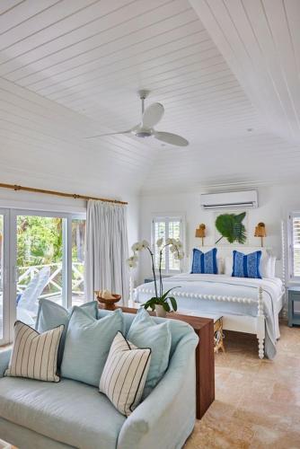 a living room with a couch and a bed at The Potlatch Club Boutique Hotel in Governorʼs Harbour